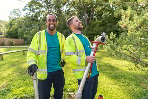 Bristol Water engineers laughing and holding onto water pipes 